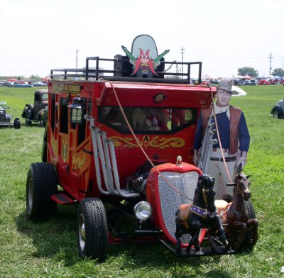 [Car made to look like stagecoach with John Wayne cardboard figure beside it and Yosemite cardboard figure inside it.]